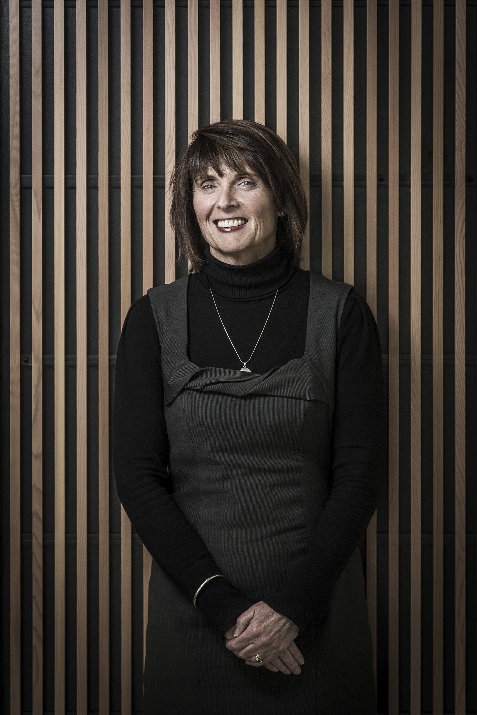 Corporate portrait of Sharon Callister Salvation Army Company Director woman leaning against wooden wall